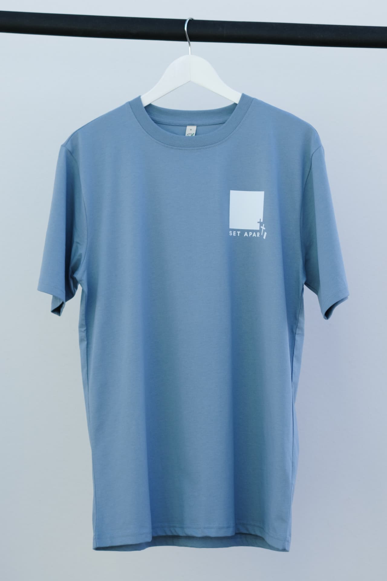 Front of the blue oversized Set Apart T-shirt with white chest print